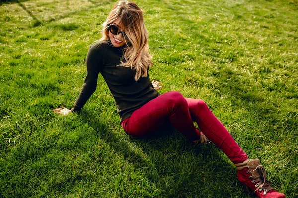 Yeşil çimenlerin üzerinde rahatlatıcı şık kadın 