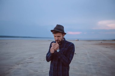 Genç adam biraz sigara sigaret günbatımı gökyüzü altında