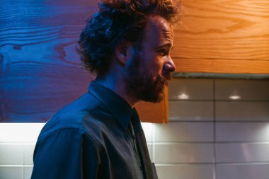 Sakallı adam karanlık gömlek daimi mutfak yan görünüm