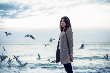 Kadın ceket ve pantolon martılar uçan ile seashore tarafından yürüyüş zevk