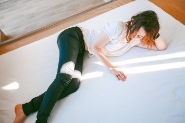 Kadın beyaz t-shirt yatakta döşeme