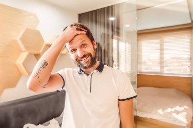 Holding el alnındaki gülümseyen yakışıklı sakallı adam 