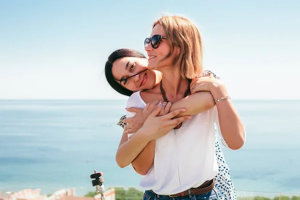 Due Donne Felici Che Abbracciano Piedi Sfondo Blu Cielo Mare — Foto Stock