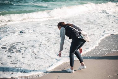 Genç kadın sonbahar deniz kenarında iyi vakit