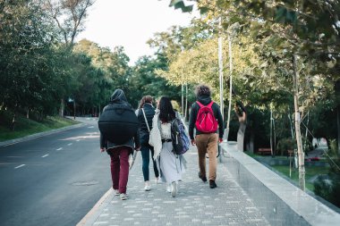 Bir grup genç insan Şehir Parkı üzerinde yürüme