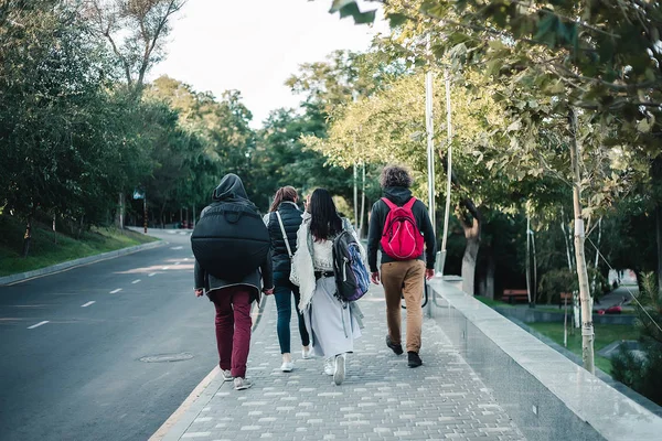 Group of young people walking on city park