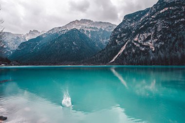 Mavi dağ gölü gri bulutlu gökyüzü altında