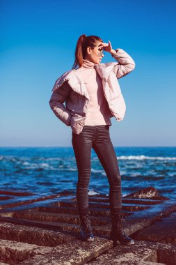 Pembe ceket sahil üzerinde poz genç şık kadın 