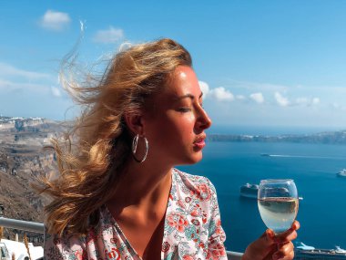 Arka plan üzerinde deniz manzarası ile şarap içme sarışın genç kadın 