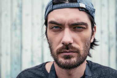 Ahşap arka plan üzerinde genç tıraşsız adam portresi görünümü Kapat