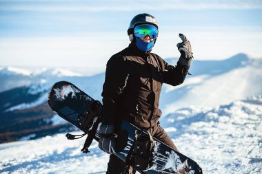 Kışın snowboard tutan portreci adam.