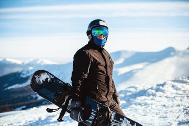 Kışın snowboard tutan portreci adam.