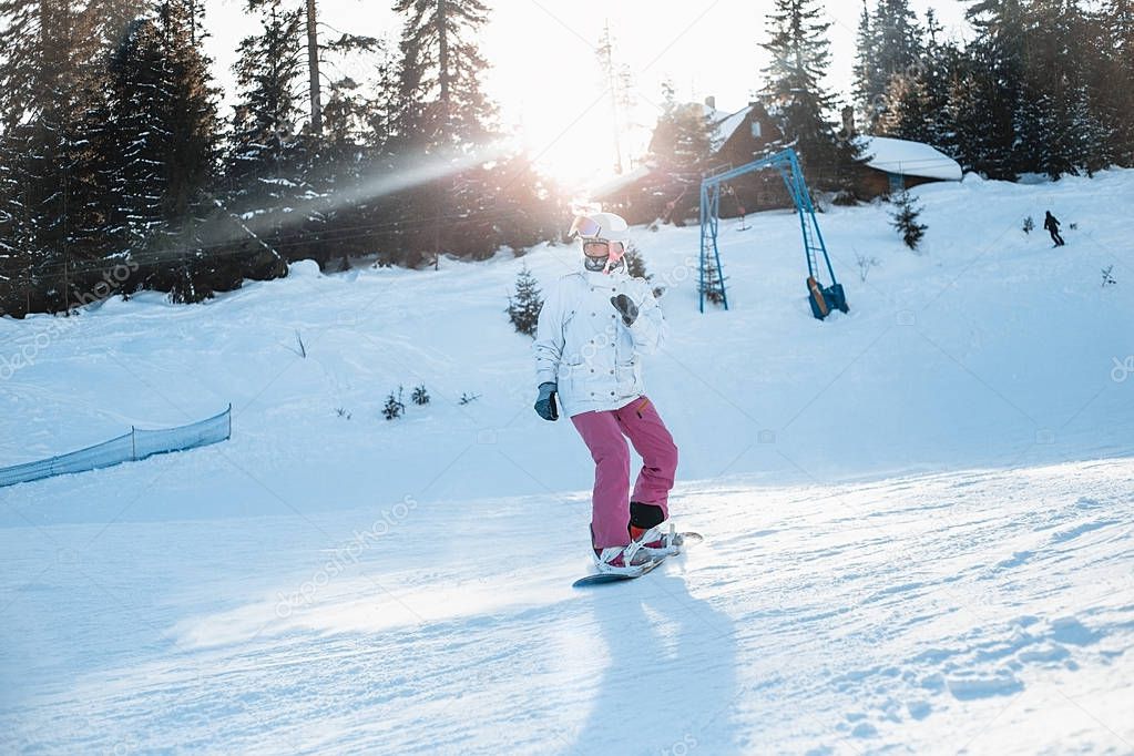 Happy woman riding snowboard in winter 