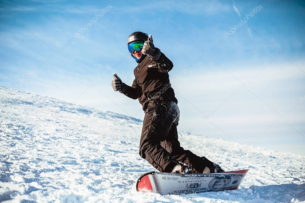 Happy man riding snowboard in winter