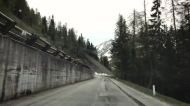 Kışın ormanla kaplı dağlardaki boş yol manzarası.