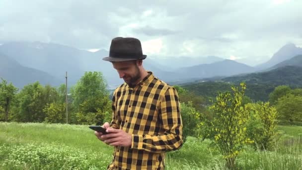 Pohledný Muž Ležérní Oblečení Pomocí Smartphone Během Procházky Mezi Horami — Stock video
