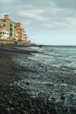 Yaz günbatımında deniz kıyısındaki şehir manzarası. 
