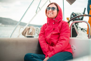 Sıcak elbiseli bir kadın güneşli bir günde yatta dinleniyor.