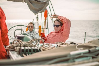 Mutlu adam ve kadın güneşli bir günde yatta dinleniyorlar.