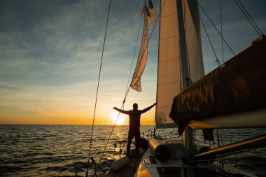Mutlu adam gün batımında yatta duruyor.