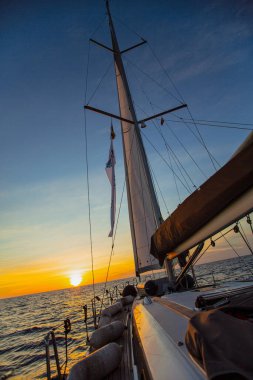 Gün batımında deniz yüzeyinde yüzen yatın resimsel görüntüsü