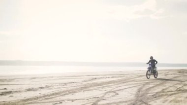 Sanddy Beach 'te motosiklet süren bisikletli adam. 