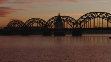 Nehir Daugava üzerinde Riga demir demiryolu köprüsünde gündoğumu