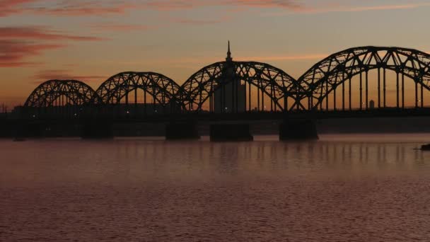 Ρίγα σιδήρου σιδηροδρομική γέφυρα πάνω από τον ποταμό Daugava με την Ανατολή — Αρχείο Βίντεο