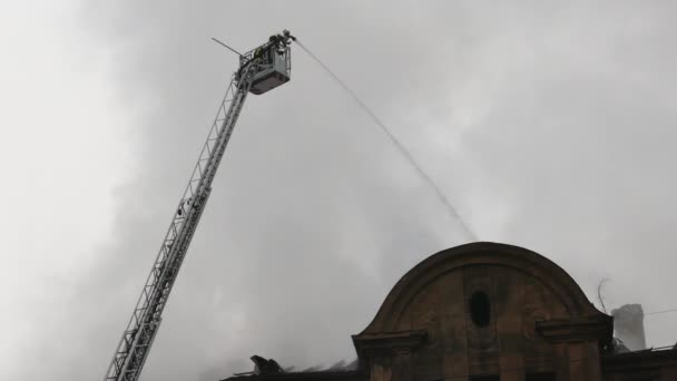 Firefighters on turntable ladder fighting fire — Stock Video
