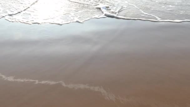 Olas marinas formando espuma blanca en la playa de arena — Vídeo de stock