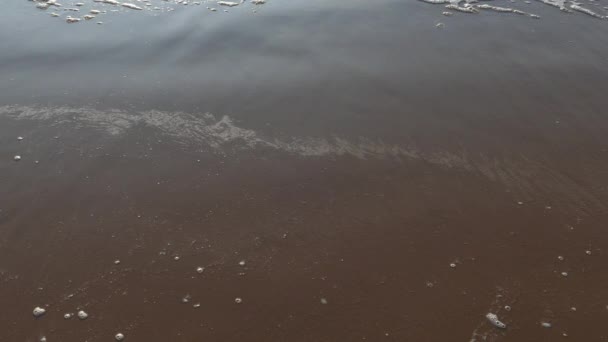 Ondas do mar formando espuma branca na praia de areia — Vídeo de Stock