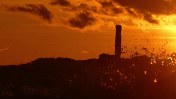 Siluetas de las olas del mar chapotean contra dramático atardecer — Vídeo de stock