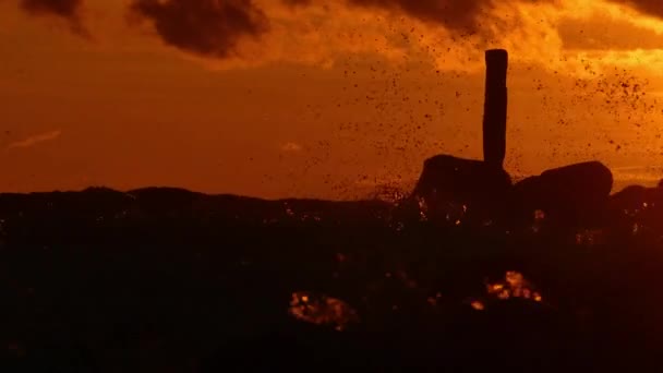 Siluetas de las olas del mar chapotean contra dramático atardecer — Vídeo de stock