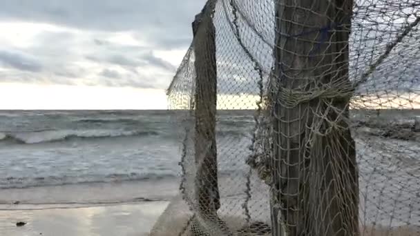 Старая рыболовная сеть висит на берегу моря — стоковое видео