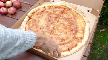 Elle pizza alıyor.