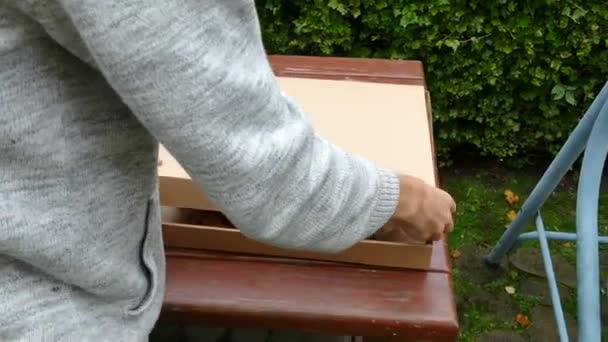 Мальчик закрывает коробку с пиццей — стоковое видео