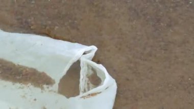 Deniz suyunda yüzen beyaz plastik torba.