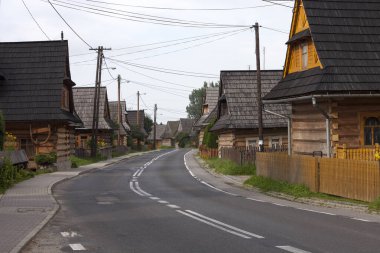 Polonya Chocholow köyünde geleneksel dağlı ahşap evleri olan bir sokak.
