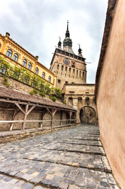 Romanya 'nın Sighisoara kentindeki Saat Kulesi kapısına giden Paved Caddesi