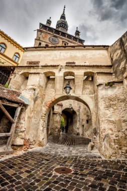 Romanya 'nın Sighisoara kentindeki Saat Kulesi kapısına giden Paved Caddesi