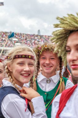 RIGA, LATVIA - 11 Temmuz 2015: Daugava Stadyumu 'ndaki Letonya Gençlik Şarkı ve Dans Festivali' nin Grand Folk dans konseri için sahne arkasında geleneksel kostümlü genç dansçılar.