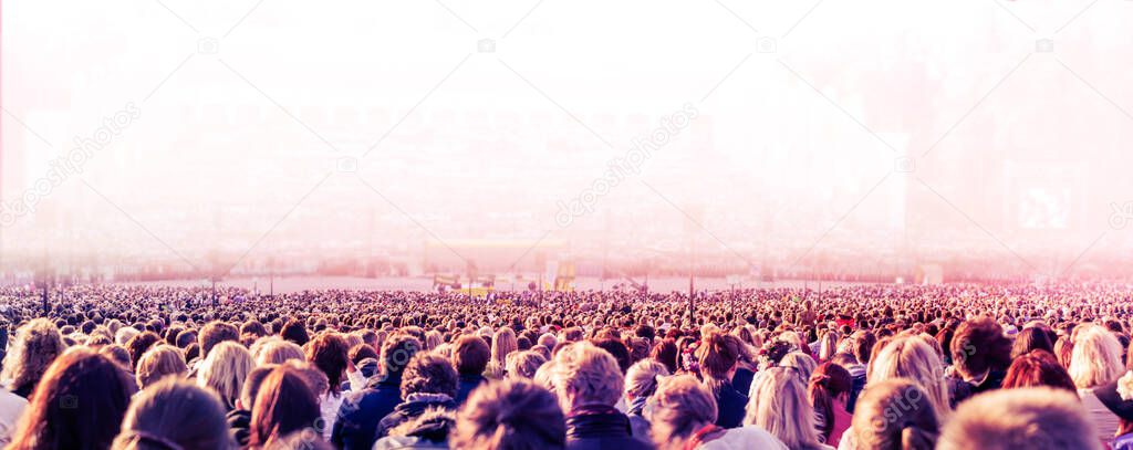 Panoramic photo of large crowd of people. Slow shutter speed with motion blur.