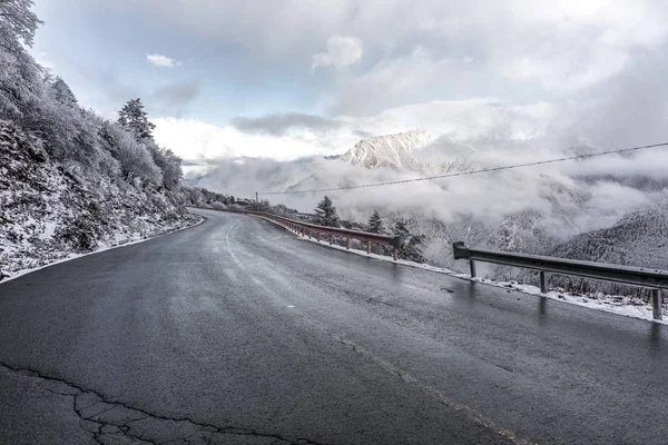 Δρόμο μέσα από το χιόνι πάνω από τα βουνά — Φωτογραφία Αρχείου