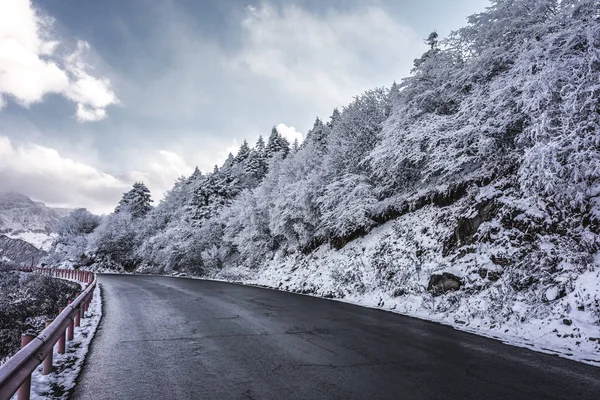 Δρόμο μέσα από το χιόνι πάνω από τα βουνά — Φωτογραφία Αρχείου