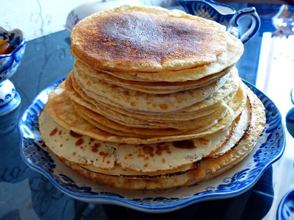 Russian blini (pancakes) on a plate Gzhel. Maslenitsa is an Eastern Slavic traditional holiday. Gzhel-Russian folk craft of ceramics and production porcelain and a kind of Russian folk painting.