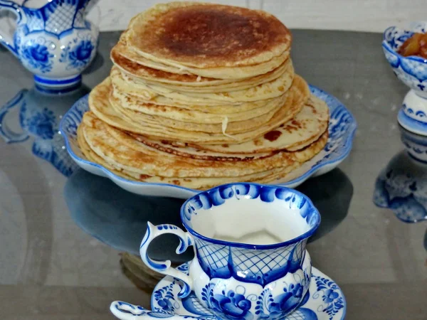 Russian blini (pancakes) on a plate Gzhel. Maslenitsa is an Eastern Slavic traditional holiday. Gzhel-Russian folk craft of ceramics and production porcelain and a kind of Russian folk painting.