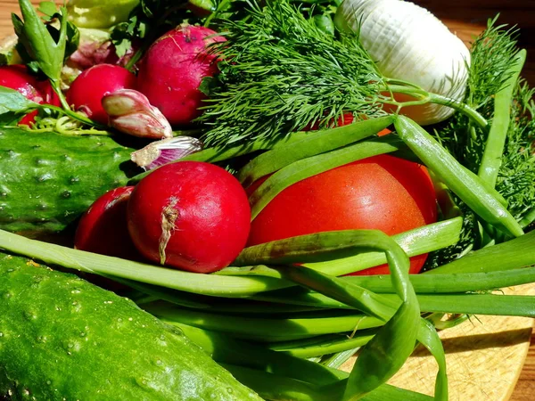 The first spring harvest from the garden. Closeup. Natural product. Salad of fresh vegetables.