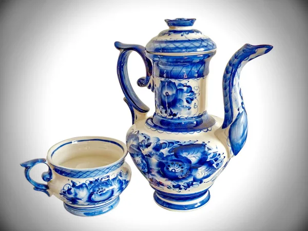 Teapot and teacup in Russian traditional Gzhel style. Gzhel-Russian folk craft of ceramics and production porcelain and a kind of Russian folk painting. Background blur, selective focus