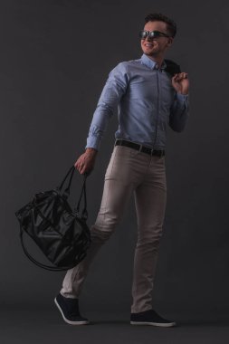 Tam boy görüntü akıllı rahat kıyafetler ve bir ihale ve gri arka plan üzerinde gülümseyen bardakları şık genç işadamı