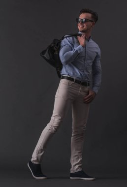 Tam boy görüntü akıllı rahat kıyafetler ve bir ihale ve gri arka plan üzerinde gülümseyen bardakları şık genç işadamı